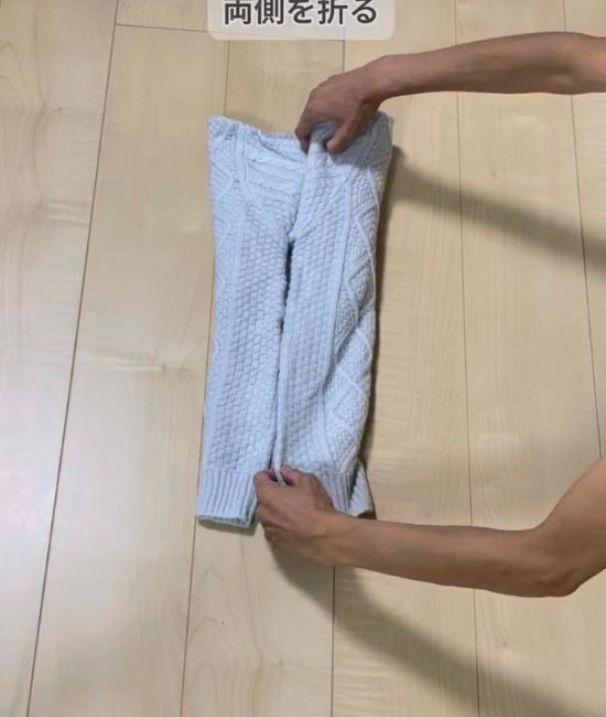 両側を真ん中に向かって折る様子