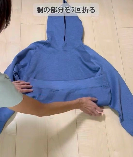 パーカーの胴部分を折る様子