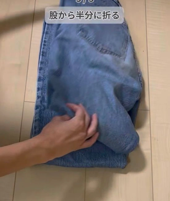 股部分から半分に折る様子