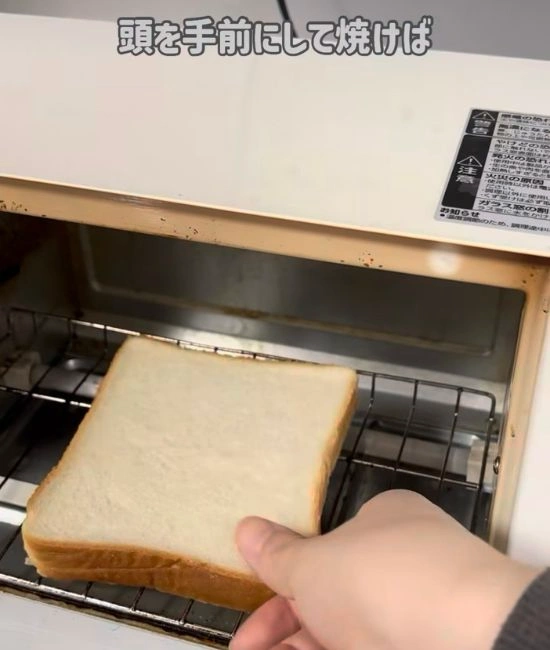 トースターに食パンを入れる様子