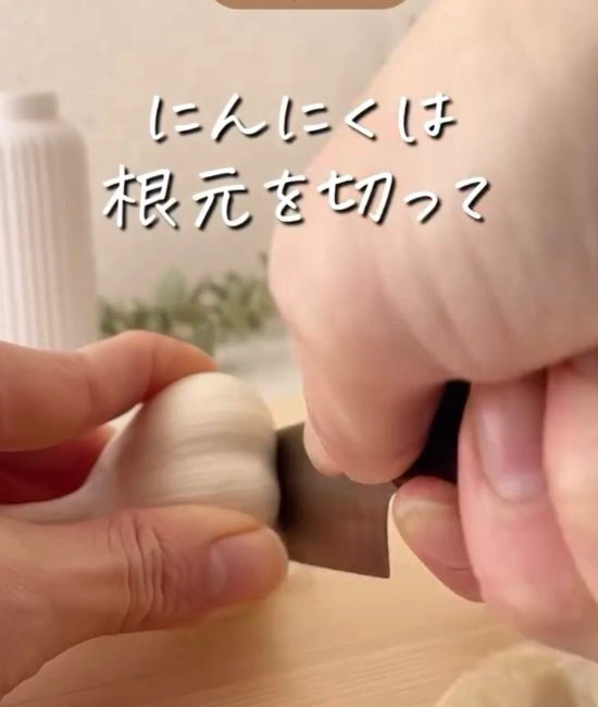 ニンニクのお尻部分を切り落とす様子