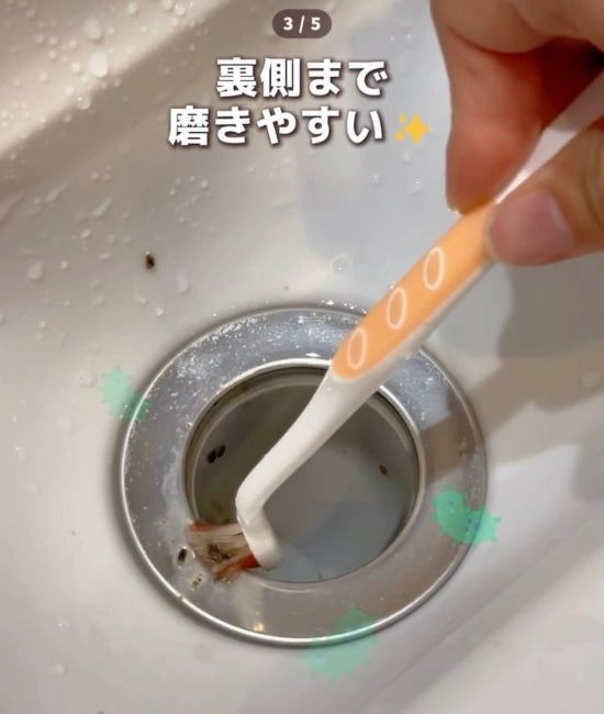 歯ブラシで排水口を掃除する様子