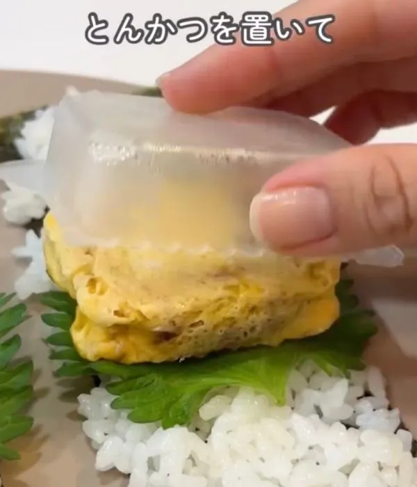 卵でとじたソースとんかつをご飯の上に置いている様子