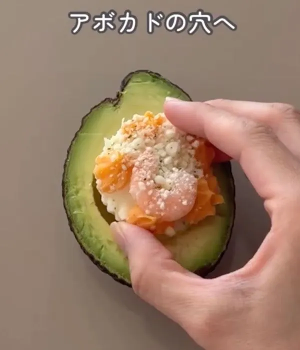 アボカドにえびとチーズのグラタンを入れている様子