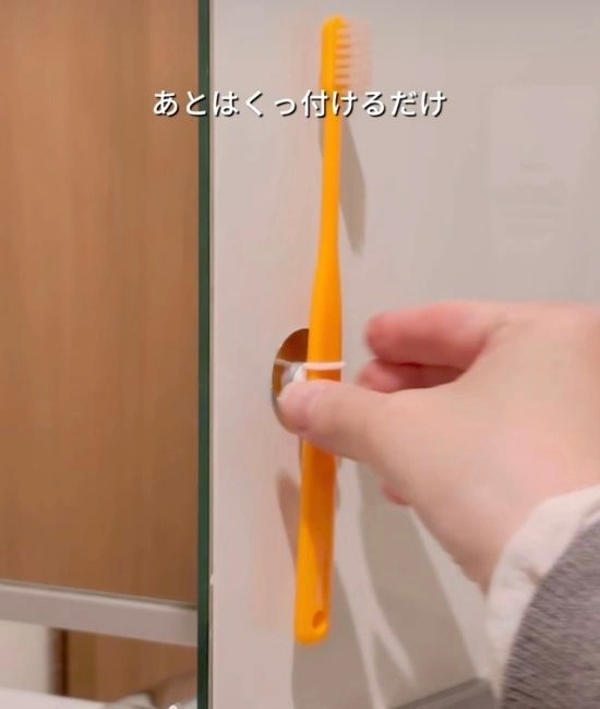 歯ブラシを扉裏につける様子