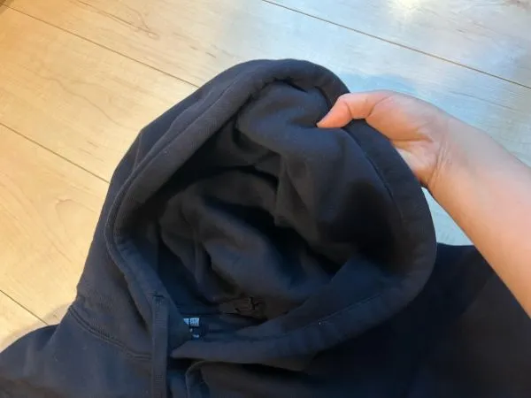 黒いパーカーのフードの湿り気を確認している様子