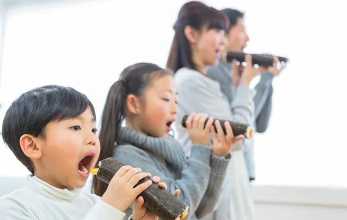 恵方を向いて恵方巻を食べている様子