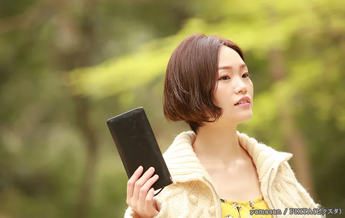 財布を持つ女性の写真