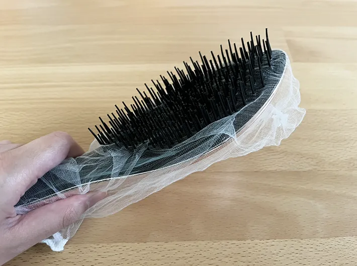 水切りネットをかぶせたヘアブラシの写真（撮影：grapeライフハック編集部）