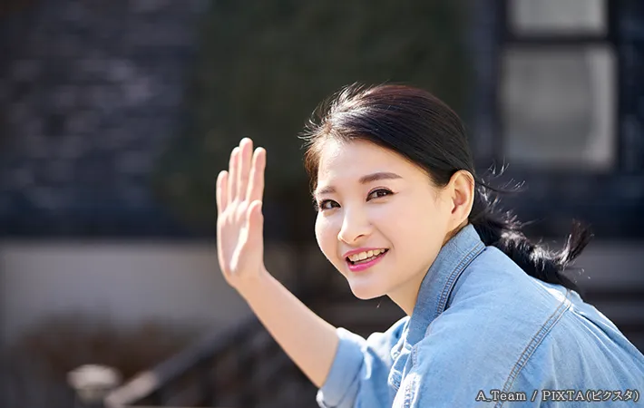 手をあげる女性の写真