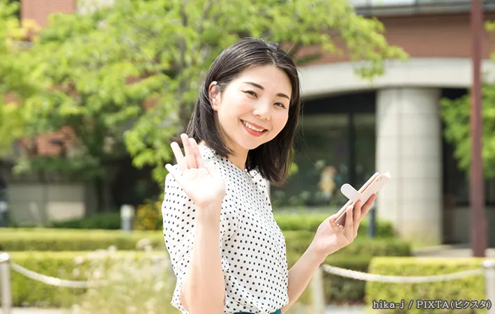 手をあげる女性の写真