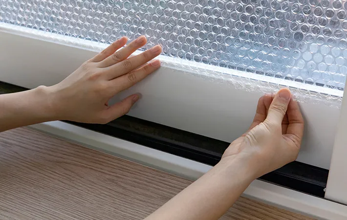 窓に断熱シートを貼っている写真