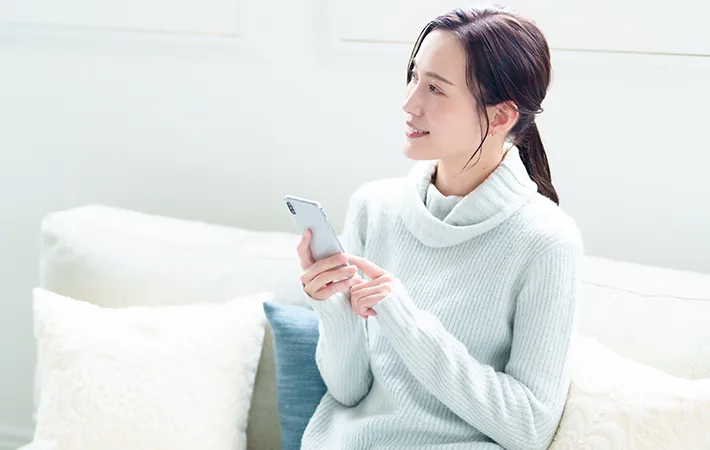 スマホを持つ女性の写真