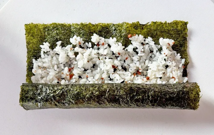 『くるくるおにぎり』のご飯を海苔で巻く写真（撮影：エニママ）