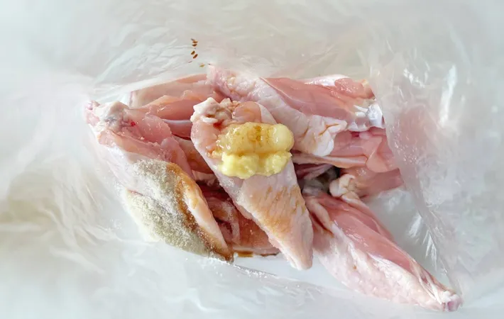 『カリカリチキンバー』の手羽元に下味をつける写真（撮影：エニママ）