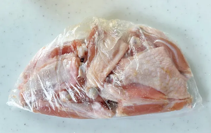 『カリカリチキンバー』の手羽元に下味をつける写真（撮影：エニママ）