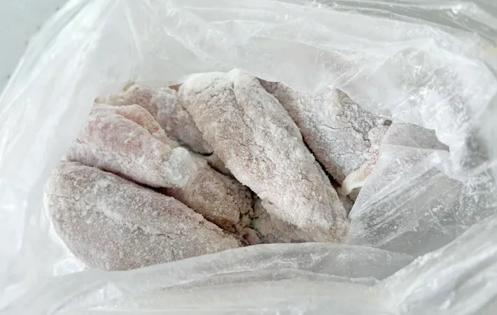 『カリカリチキンバー』の手羽元に片栗粉をまぶす写真（撮影：エニママ）