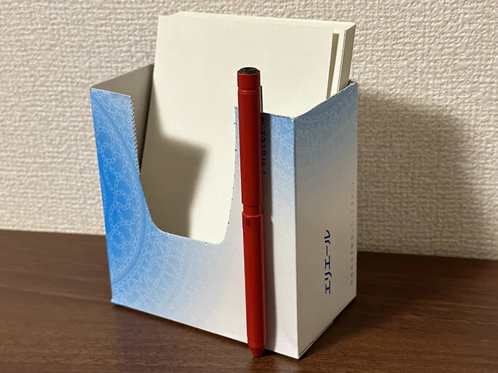 ティッシュの空き箱を半分にカットしてハガキを入れている画像（撮影：grapeライフハック編集部）