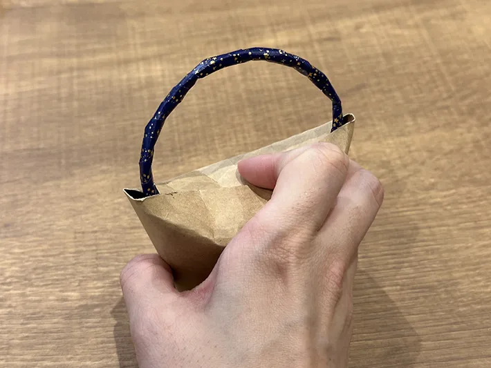 マスキングテープを巻いた飲み口部分を紙コップに挟んでいる画像（撮影：grapeライフハック編集部）