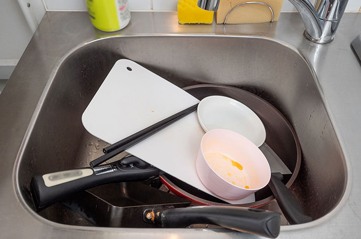 洗い物がたまったシンクの写真