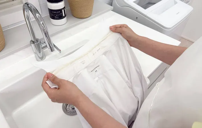 『シャツの襟を確認する女性』の写真（撮影：Heulie）