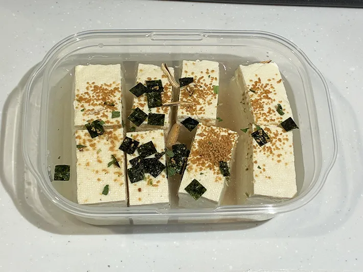 タッパーの中に並べ、調味料を入れた木綿豆腐の写真（撮影：grapeフード編集部）