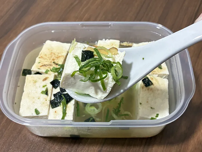 レンゲですくう湯豆腐の写真（撮影：grapeフード編集部）