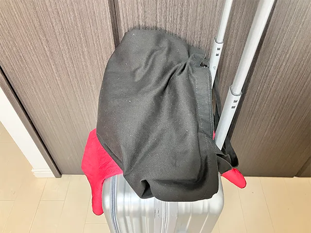 キャリーケースの持ち手に通した風呂敷の上にカバンを置く（撮影：grapeライフハック編集部）