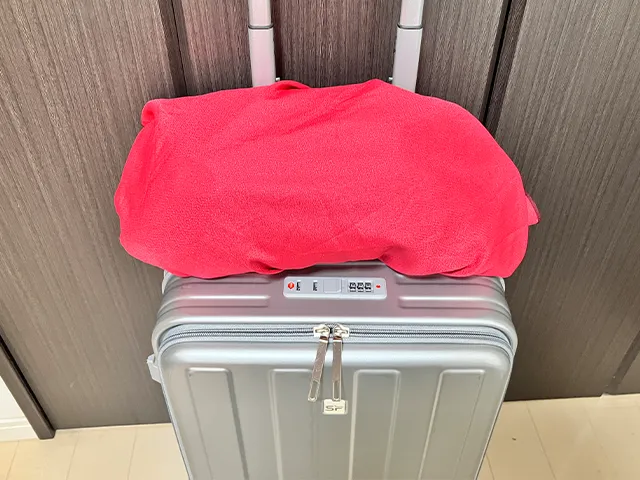 キャリーケースの上に置いたカバンを風呂敷で包む（撮影：grapeライフハック編集部）