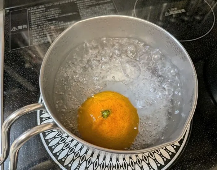 ミカンを鍋に入れている様子（撮影：grapeフード編集部）