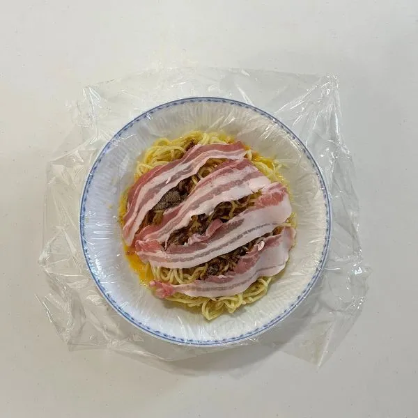 焼きそばの具材を麺の上においている様子（撮影：grapeフード編集部）