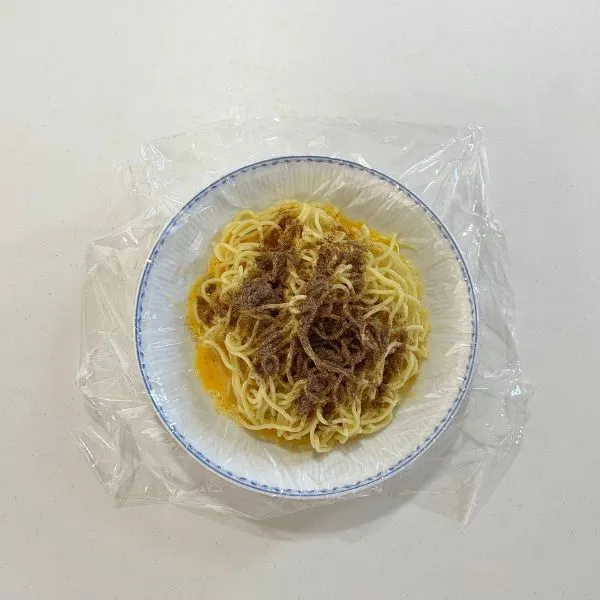 麺に粉末ソースをかけている様子（撮影：grapeフード編集部）