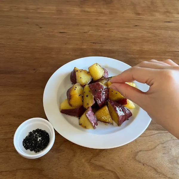大学芋にゴマを振りかけている様子（撮影：grapeフード編集部）