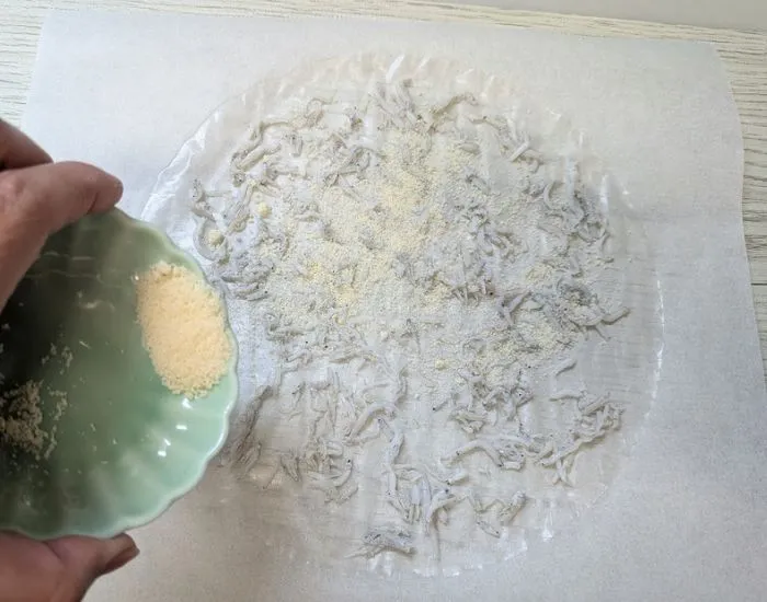 粉チーズをかけている様子（撮影：grapeフード編集部）