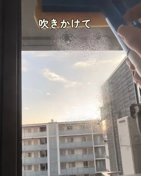 窓に水を吹きかけている様子