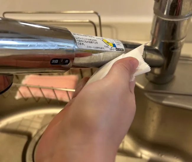 蛇口をクッキングシートでこすっている様子（撮影：grapeライフハック編集部）