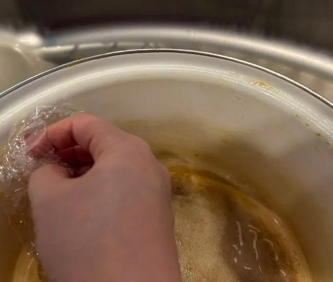 ラップで鍋を擦っている様子（撮影：grapeライフハック編集部）