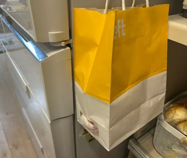 冷蔵庫の横にかけられた紙袋（撮影：grapeライフハック編集部）