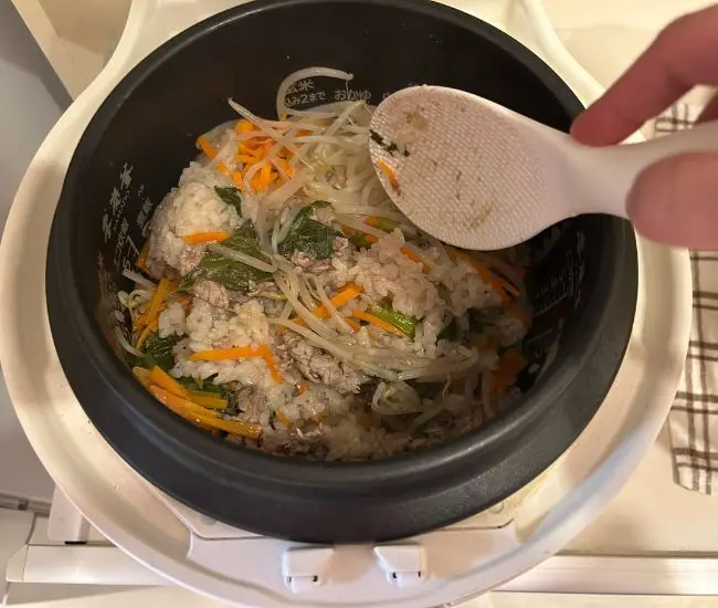 炊き上がったビビンバを混ぜている様子（撮影：grapeフード編集部）