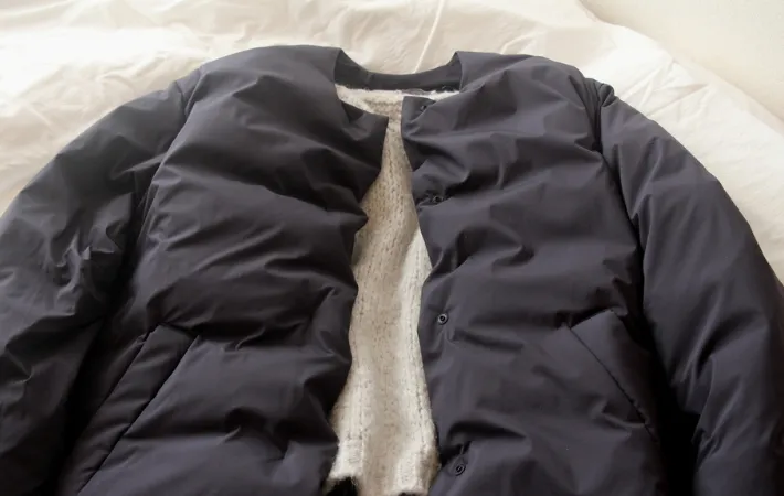 セーターに重ねられたダウンジャケット