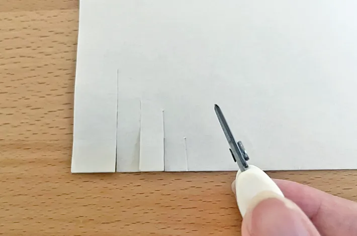 『超ミニ携帯ハサミ』で紙を切っている写真（撮影：grapeライフハック編集部）