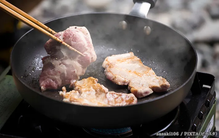 フライパンで肉を焼いている写真