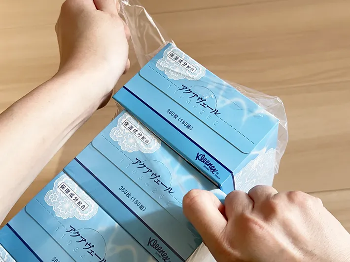 ティッシュの外装ビニールを無理やり開けている画像（撮影：grapeライフハック編集部）