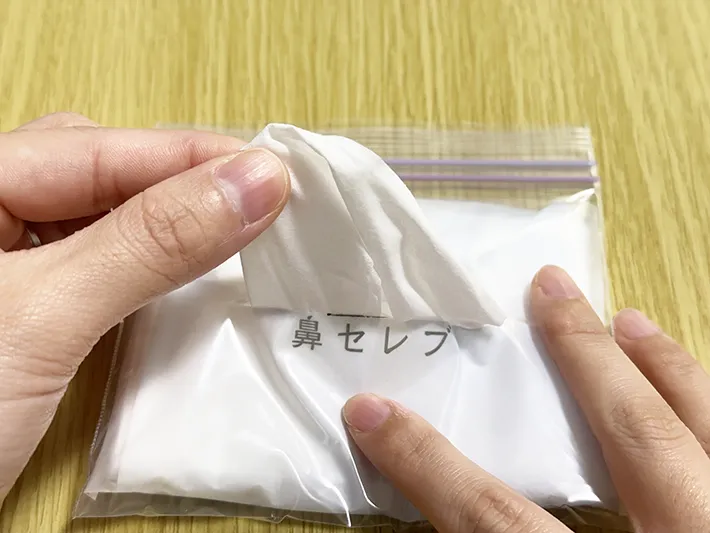 自作のポケットティッシュケースからティッシュを取り出している画像（撮影：grapeライフハック編集部）