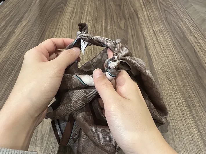 ハンカチの片方で穴を作り、もう一方を通そうとしている画像（撮影：grapeライフハック編集部）