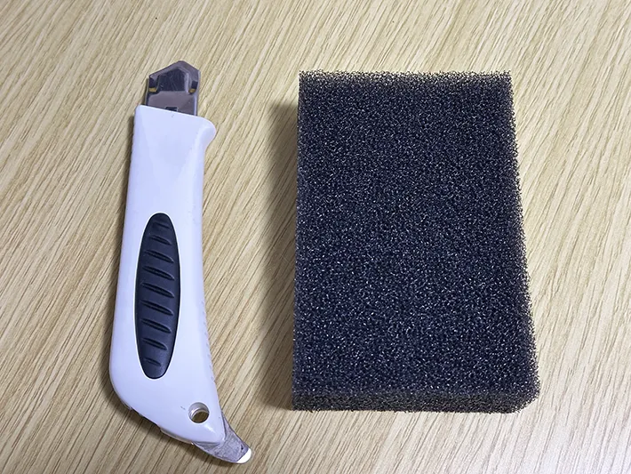カッターと食器用スポンジを並べた画像（撮影：grapeライフハック編集部）