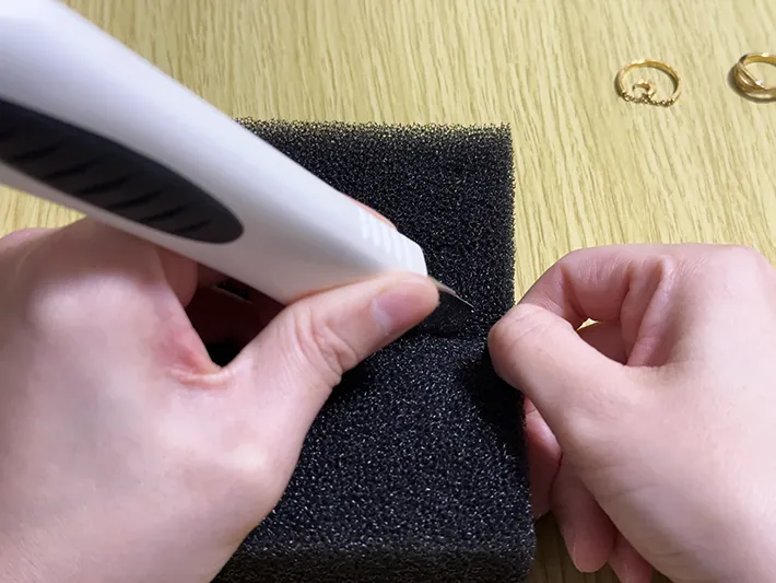 片手を添え、スポンジにカッターで切り込みを入れている画像（撮影：grapeライフハック編集部）