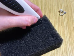 食器用スポンジにイヤリング用の切り込みを入れている画像（撮影：grapeライフハック編集部）