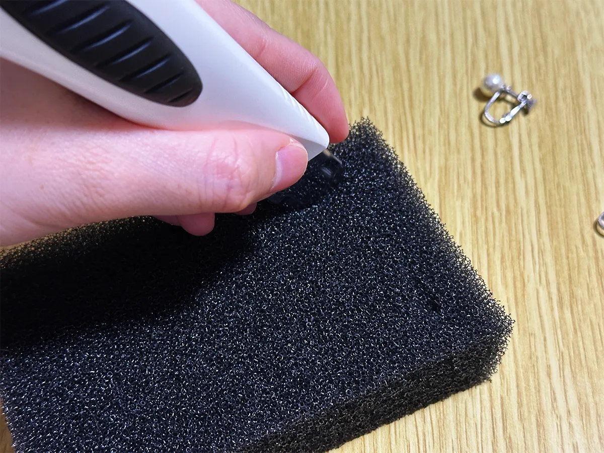 食器用スポンジにイヤリング用の切り込みを入れている画像(撮影:grapeライフハック編集部)