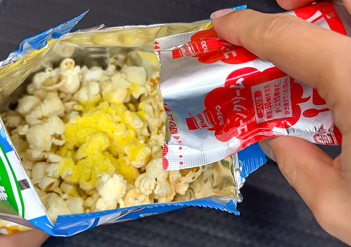 ポップコーンの袋にコーンポタージュの素を入れる写真（撮影：キジカク）